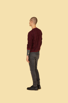 Three-quarter back view of an unknown man in a red sweater