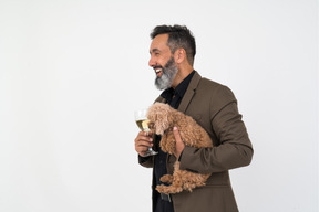 Hombre maduro con una copa de champán y un cachorro
