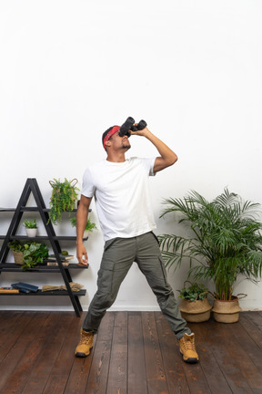 Good looking young man holding binoculars