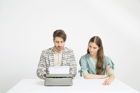 Pareja sentada a la mesa y trabajando en la novela.