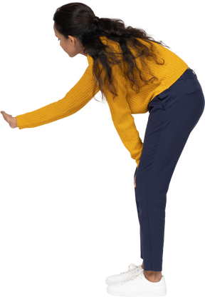 Side view of a girl in casual clothes bending down and explaining something