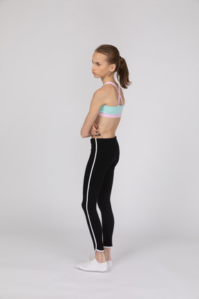 Angry teen girl standing with her arms crossed