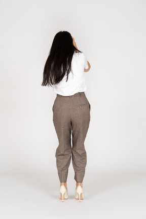 Back view of a scared young woman in breeches touching her head