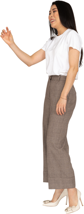 Three-quarter view of a young woman in breeches and white t-shirt showing a size of something