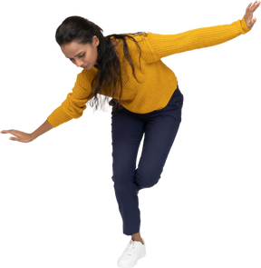 Front view of a girl in casual clothes posing on one leg with outstretched arms