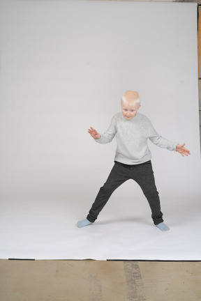 Boy in casual clothes raising hands