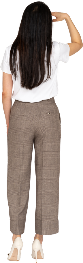 Back view of a young woman in breeches looking for something