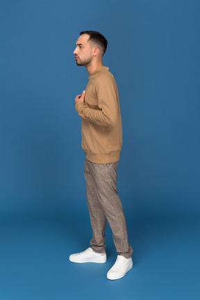 Serious young man touching chest