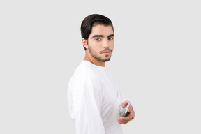 Jovem bonito olhando para a câmera e apontando com o telefone