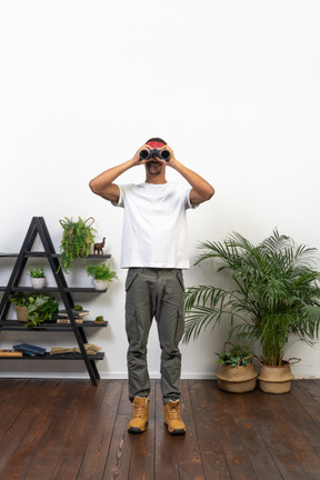 Good looking young man holding binoculars