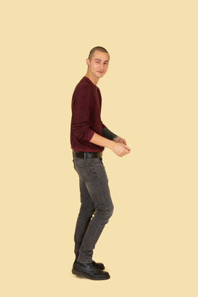 Side view of a young man in red pullover turning head