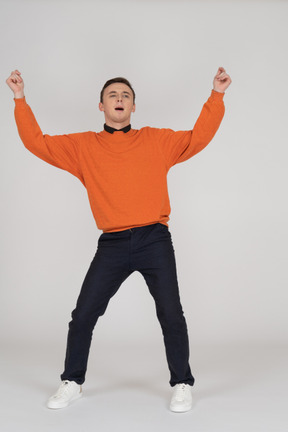 Young man in orange sweatshirt posing