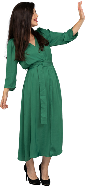 Three-quarter view of a greeting young lady in green dress