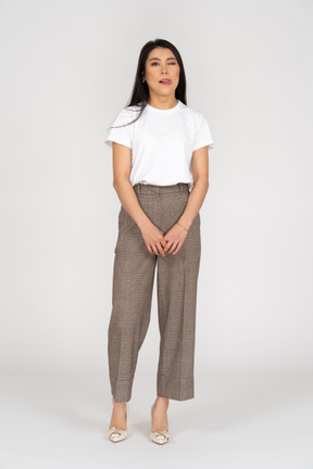 Front view of a winking young lady in breeches and t-shirt showing tongue