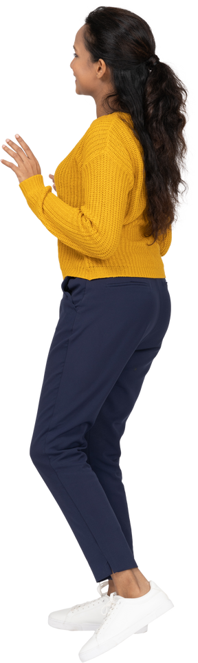 Side view of a happy girl in casual clothes showing stop gesture