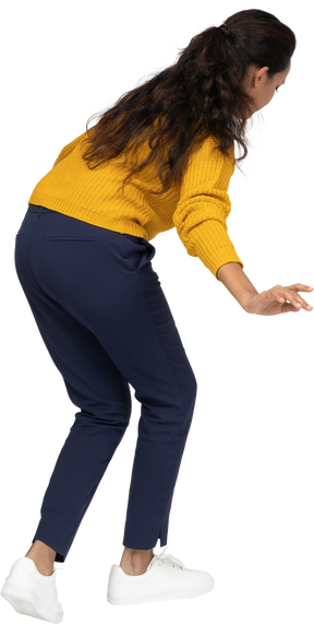 Side view of a girl in casual clothes bending down with outstretched arms