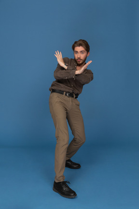 A slim young man showing a stop sign