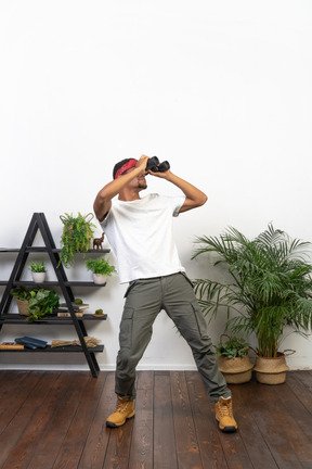 Good looking young man holding binoculars